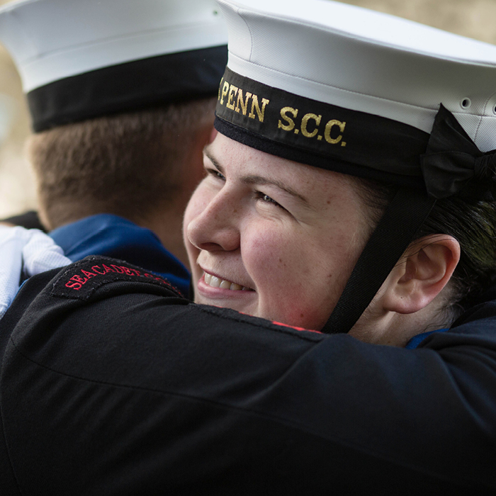 Two Sea Cadets smiling and hugging